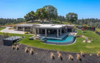 view of the estate villa, infinity terrace, pool and hot tub